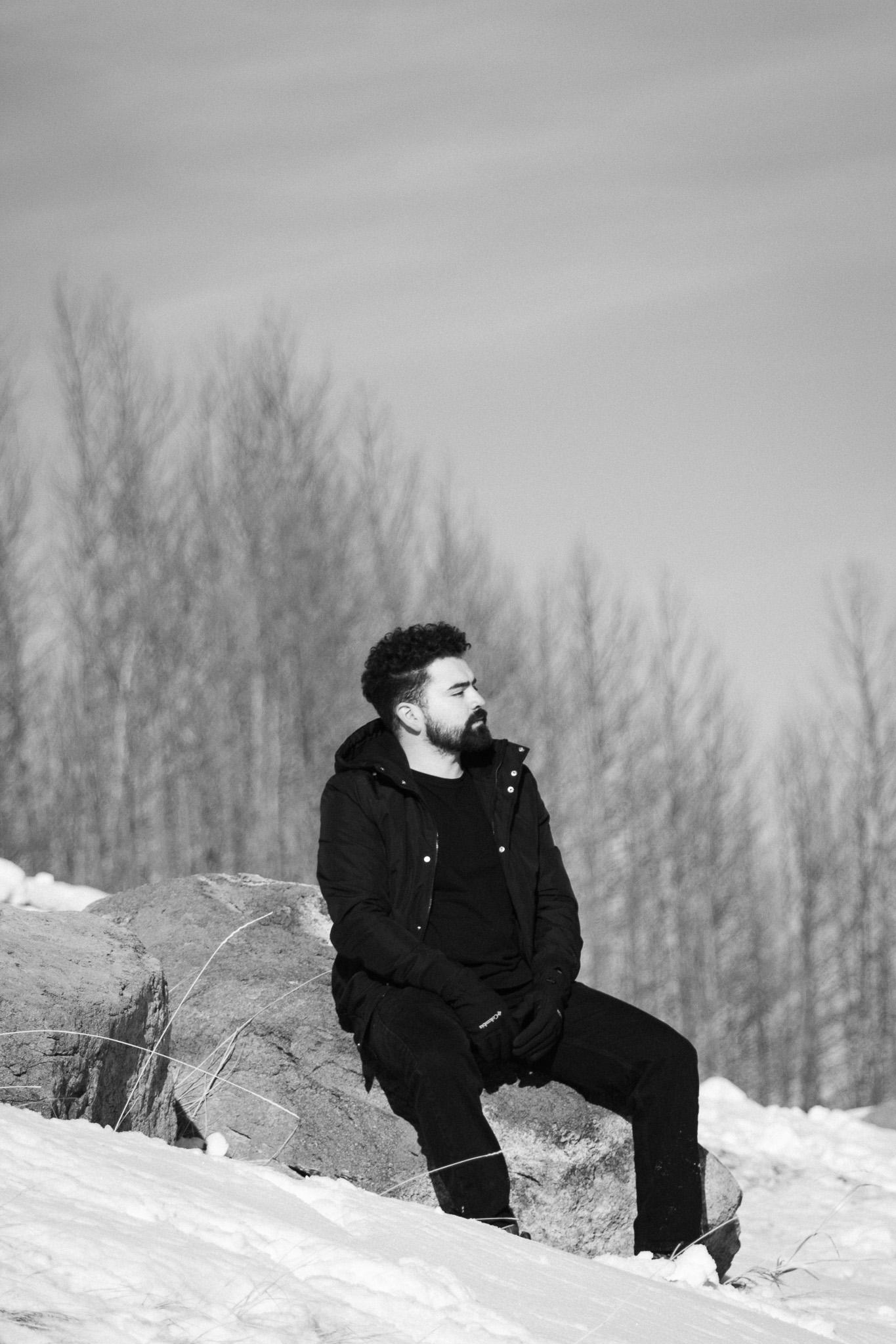 Retrato en blanco y negro sobre una roca en la nieve